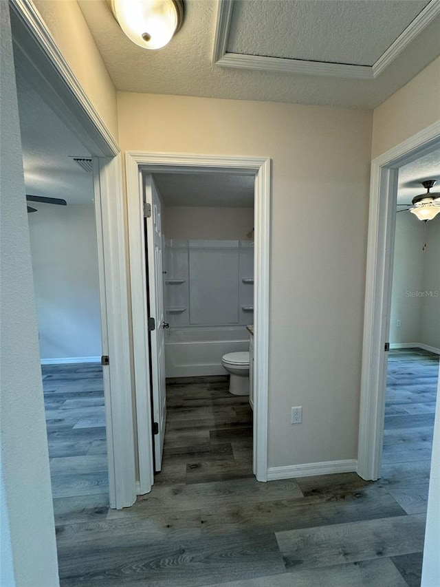 bathroom with tub / shower combination, wood-type flooring, a textured ceiling, and toilet