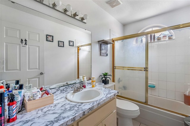 full bathroom featuring oversized vanity, combined bath / shower with glass door, tile floors, and toilet