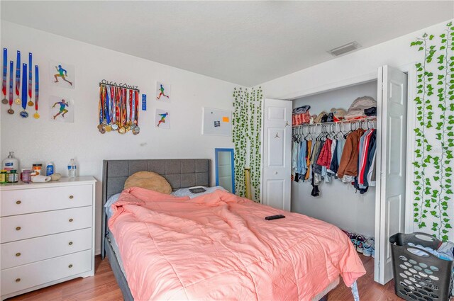 bedroom featuring wood-type flooring and a closet