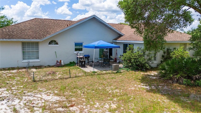 rear view of property with a yard and a patio