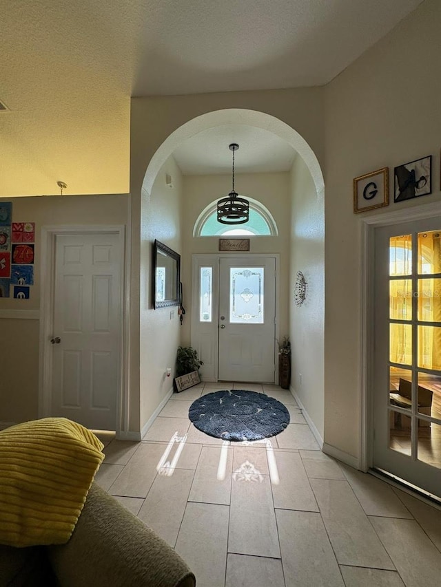 entryway featuring plenty of natural light, a textured ceiling, and light tile flooring