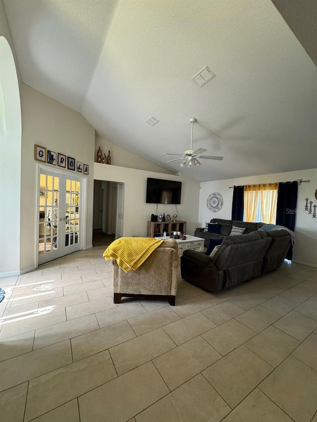 living room with lofted ceiling, french doors, ceiling fan, and light tile floors