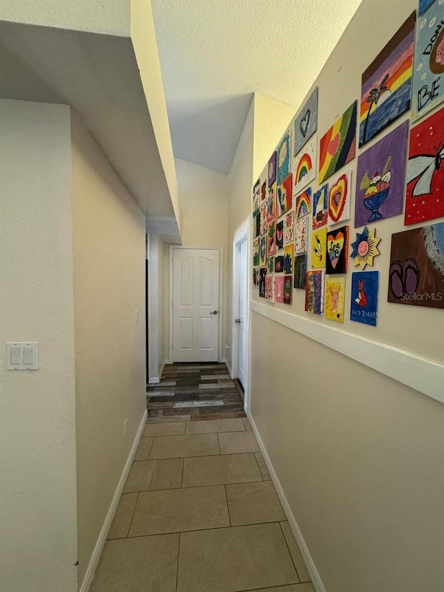 hall featuring tile flooring and a textured ceiling