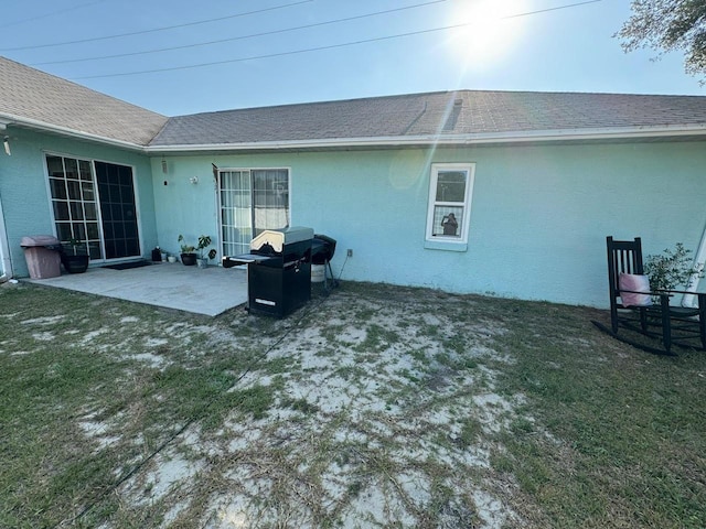 rear view of house with a patio and a lawn