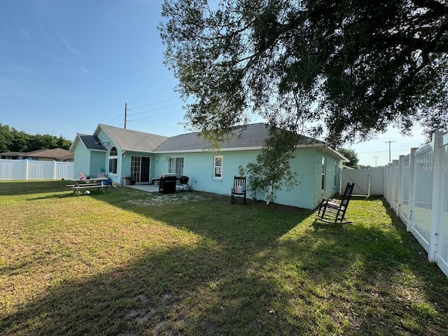 back of property featuring a patio and a yard