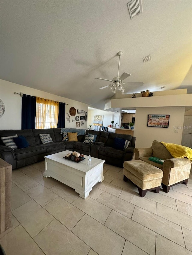 tiled living room featuring ceiling fan and a textured ceiling