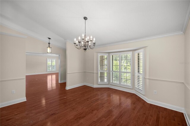 empty room featuring crown molding, dark hardwood / wood-style flooring, lofted ceiling, and a notable chandelier