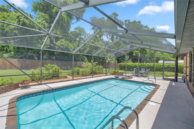 view of pool with glass enclosure and a patio area