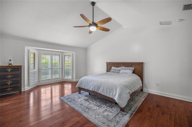 bedroom featuring ceiling fan, dark wood-type flooring, ornamental molding, and lofted ceiling