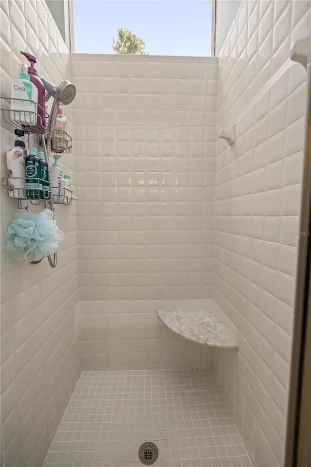 bathroom featuring plenty of natural light and tiled shower