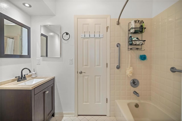 bathroom with tile patterned floors, vanity, and tiled shower / bath