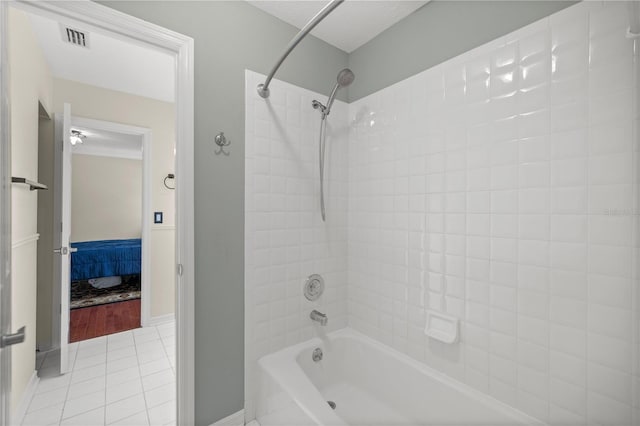 bathroom with tile patterned flooring and tiled shower / bath combo