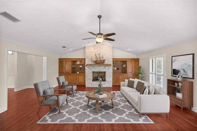 living room featuring ceiling fan, a brick fireplace, built in shelves, and wood-type flooring