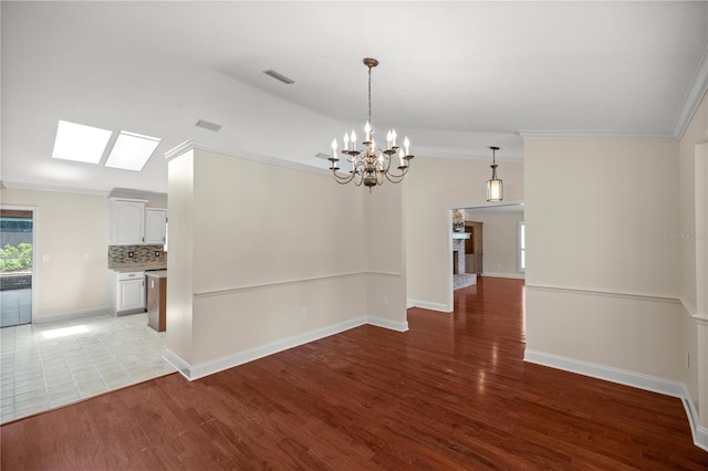 unfurnished dining area with light hardwood / wood-style flooring, a skylight, an inviting chandelier, and crown molding