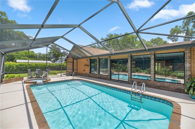 view of swimming pool featuring a lanai, an in ground hot tub, and a patio