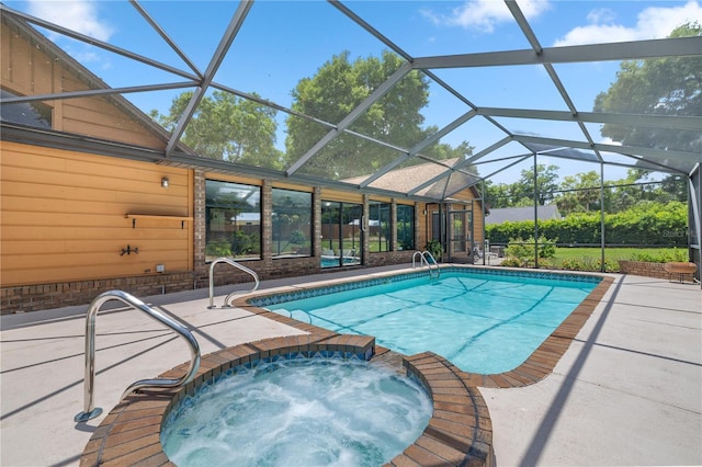 view of pool with a lanai, a patio, and an in ground hot tub