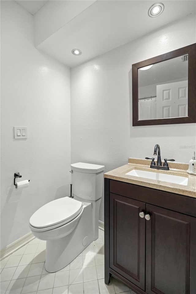 bathroom featuring vanity, tile patterned floors, and toilet