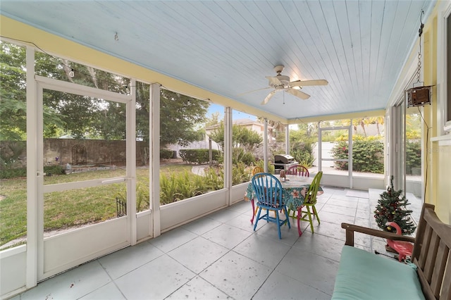 unfurnished sunroom with ceiling fan and wooden ceiling