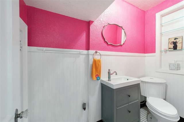 bathroom featuring vanity, a textured ceiling, and toilet