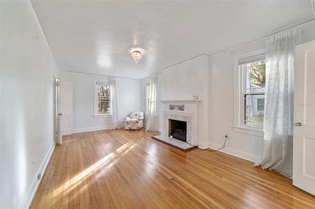 unfurnished living room with a fireplace and light wood-type flooring