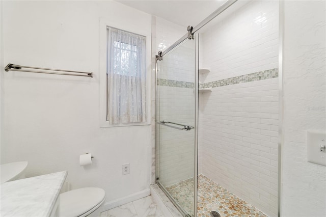 bathroom with a shower with door, vanity, and toilet