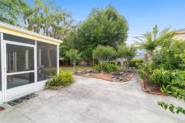 view of patio with a sunroom and fence