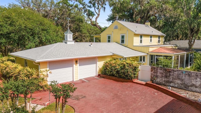 view of front of house featuring a garage, driveway, and a shingled roof