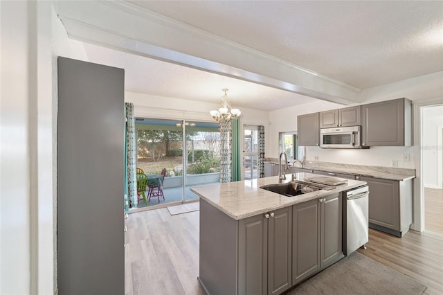 kitchen with light wood-style flooring, a sink, stainless steel appliances, gray cabinetry, and a notable chandelier