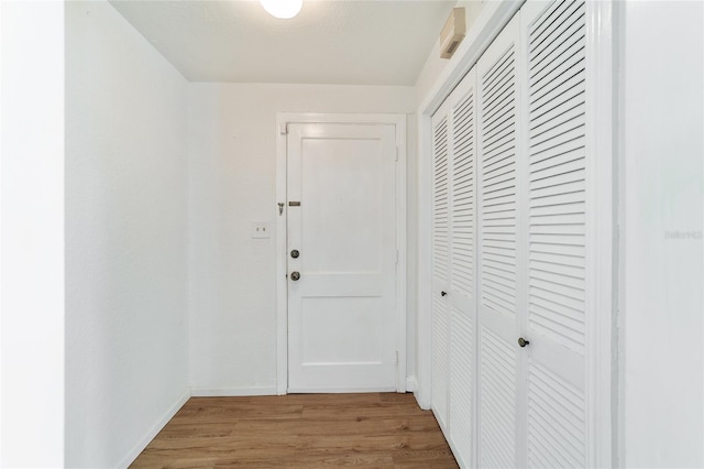 hallway featuring wood finished floors and baseboards