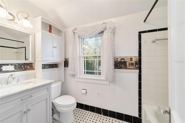 bathroom with washtub / shower combination, vanity, and toilet