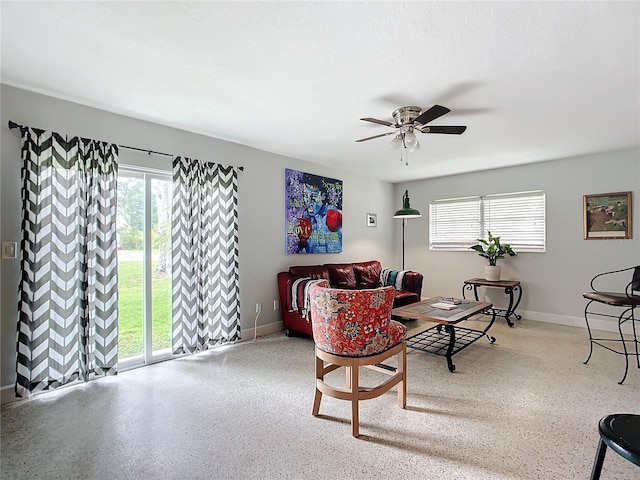 living room with ceiling fan, a healthy amount of sunlight, and a textured ceiling