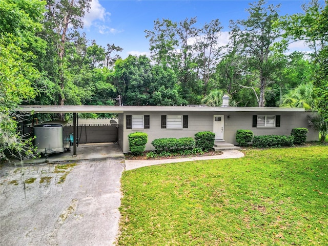 ranch-style house featuring a carport and a front yard