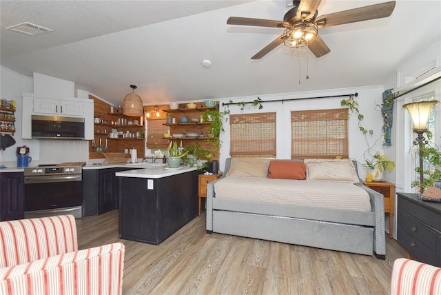 bedroom featuring ceiling fan, light hardwood / wood-style flooring, multiple windows, sink, and lofted ceiling