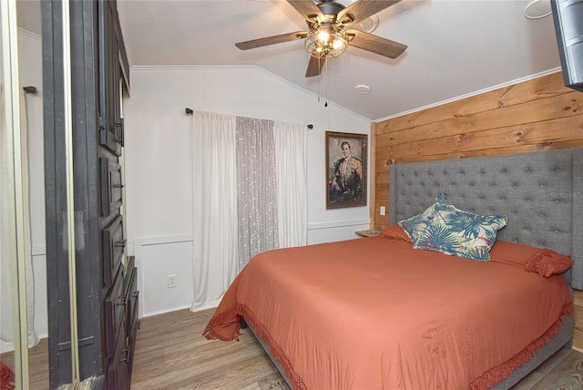 bedroom with hardwood / wood-style flooring, lofted ceiling, ornamental molding, and ceiling fan