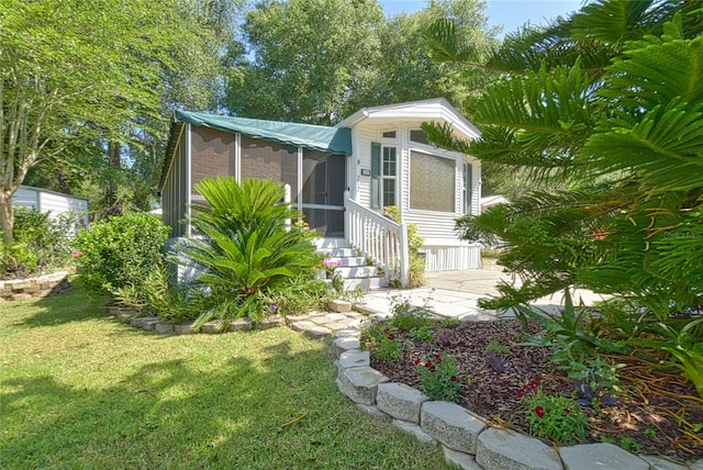 view of front of home with a sunroom and a front lawn