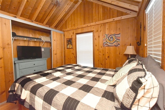 bedroom featuring vaulted ceiling with beams, wooden walls, and a closet