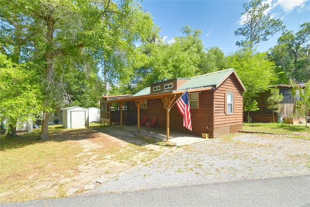 view of front of house with a carport and a storage unit