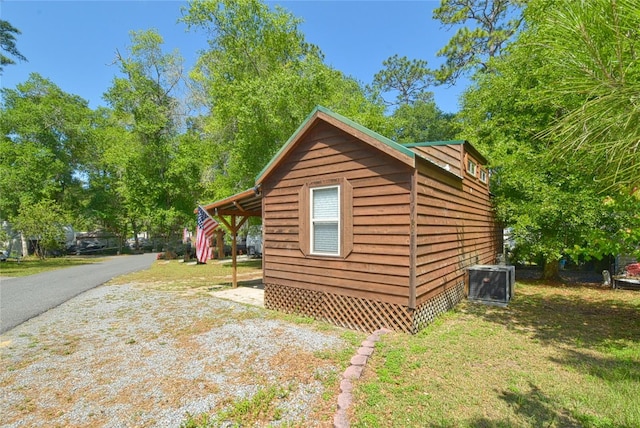 view of shed / structure featuring central AC unit and a lawn