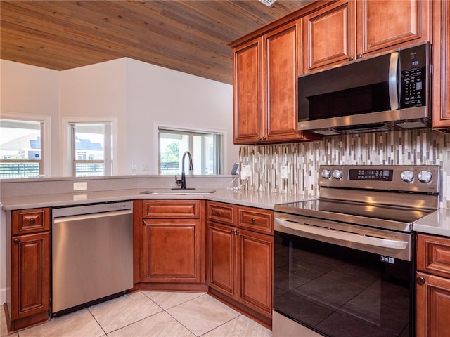 kitchen featuring appliances with stainless steel finishes, light tile flooring, backsplash, sink, and wooden ceiling