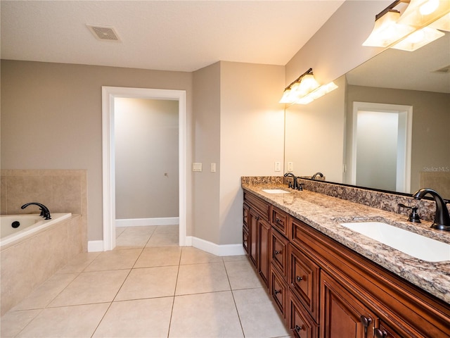 bathroom with tile floors, dual sinks, vanity with extensive cabinet space, and tiled tub