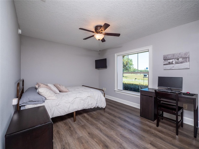 bedroom with a textured ceiling, dark hardwood / wood-style floors, and ceiling fan