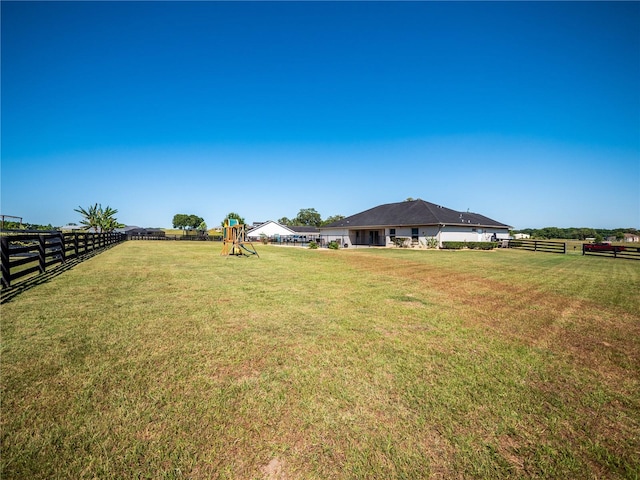 view of yard with a playground and a rural view