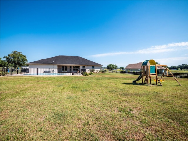 view of yard with a playground and a fenced in pool