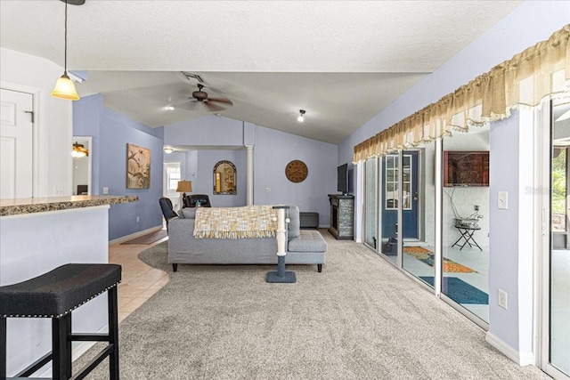 living room featuring ceiling fan, plenty of natural light, light colored carpet, and lofted ceiling