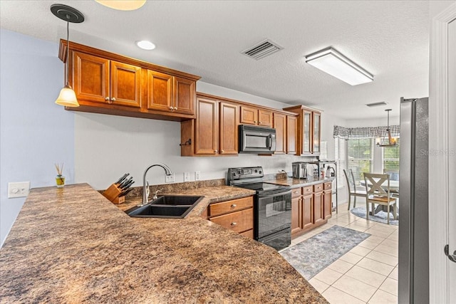 kitchen with a textured ceiling, sink, black appliances, pendant lighting, and light tile patterned floors