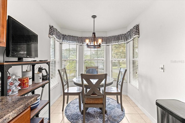 dining area featuring a wealth of natural light, light tile patterned floors, a textured ceiling, and a notable chandelier