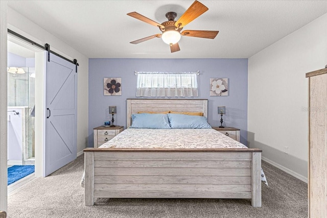 carpeted bedroom featuring a barn door, ceiling fan, and connected bathroom