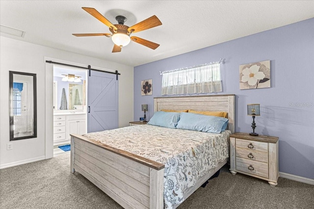 carpeted bedroom with ceiling fan, a barn door, and ensuite bathroom