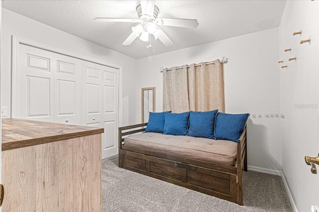 sitting room with carpet flooring, a textured ceiling, and ceiling fan