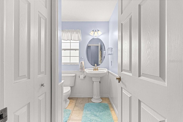 bathroom featuring tile patterned floors, toilet, and a textured ceiling